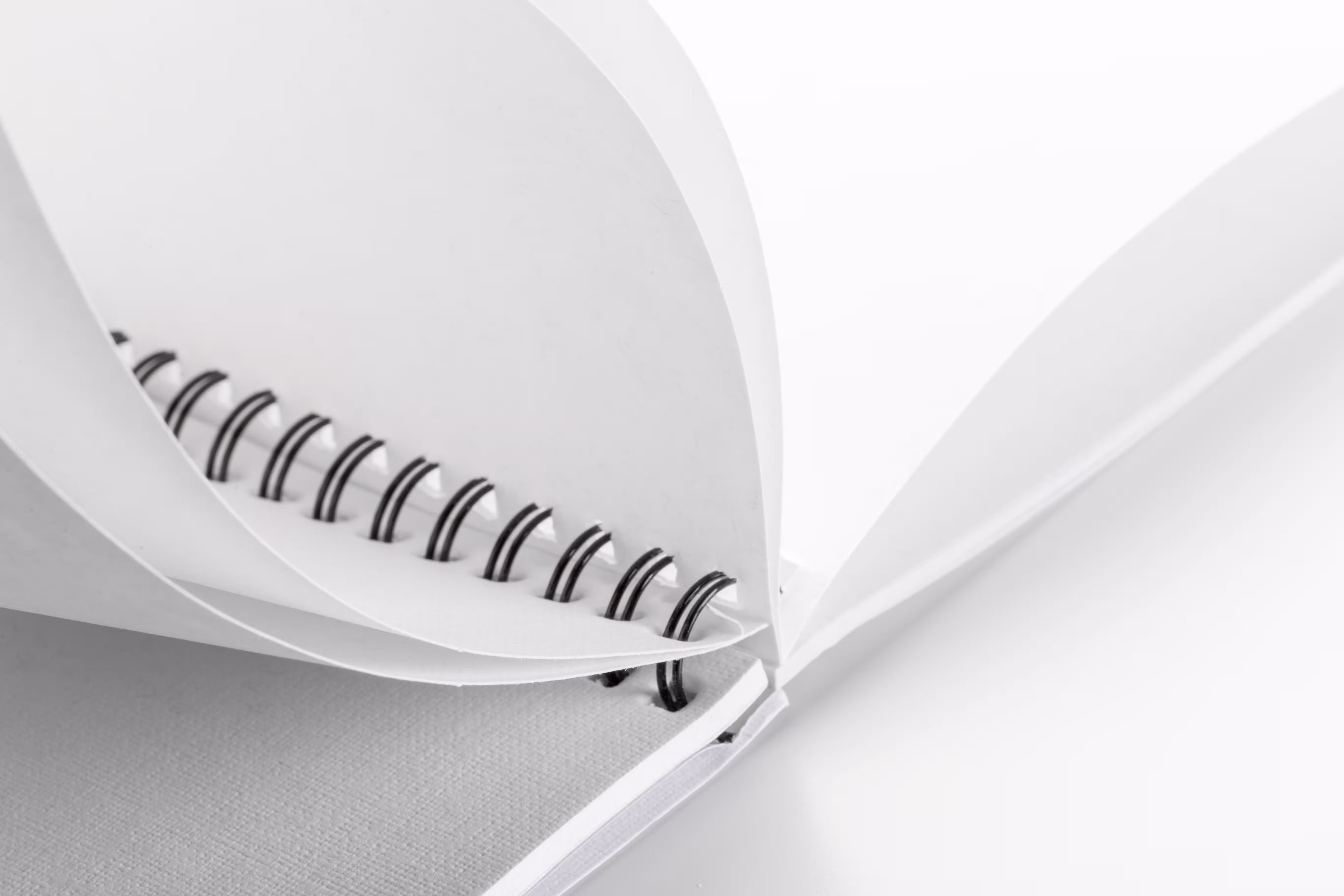 Open spiral notebook with blank white pages shown in close-up view.